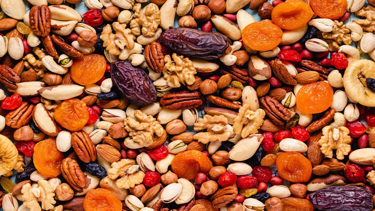 A close-up shot of assorted nuts, dates, and dried apricots, ideal as healthy bulk snacks in Malaysia.