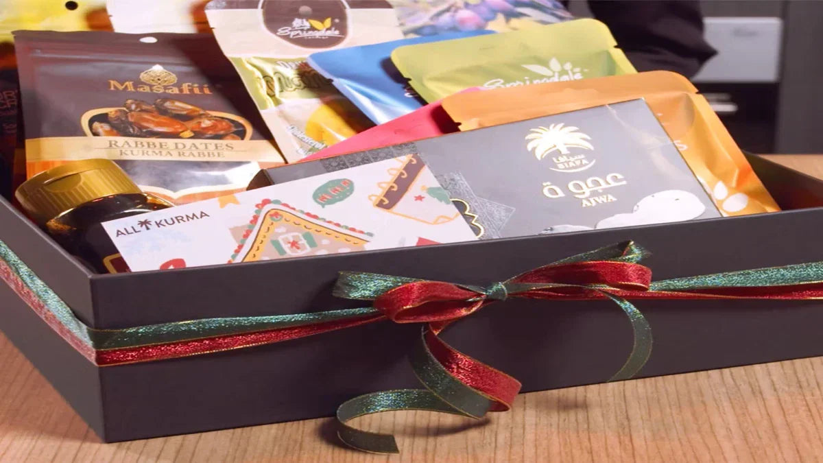 A premium box tied with a ribbon and filled with packaged dates and snacks, arranged as a corporate gift.